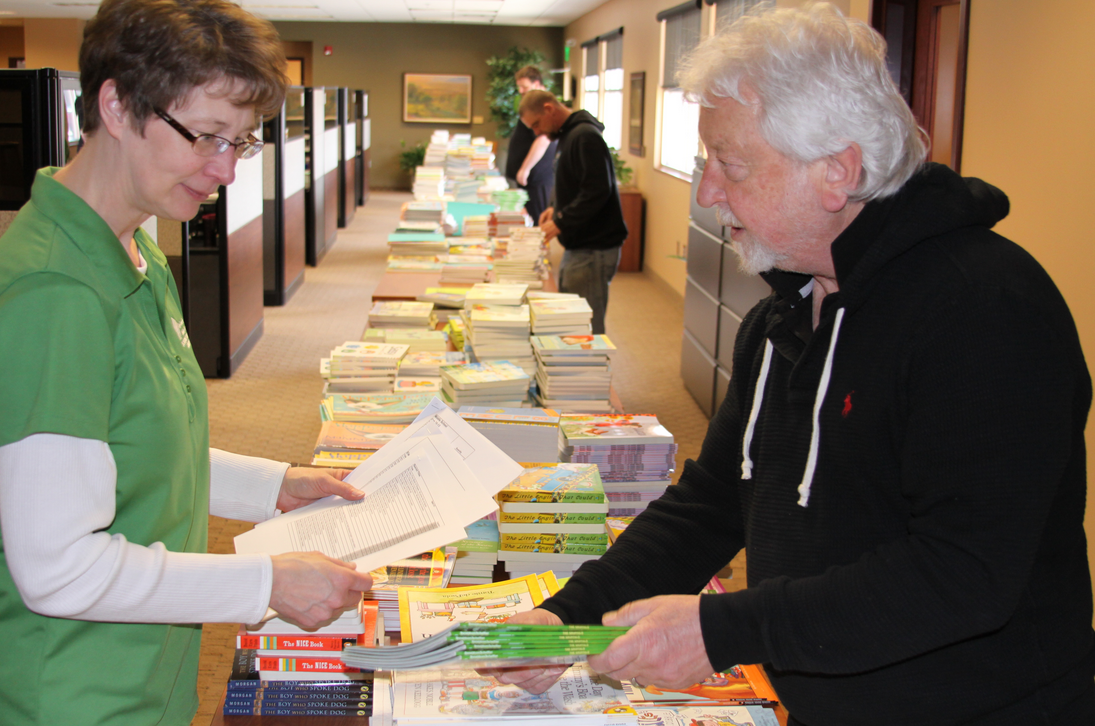Local volunteers and SWIF staff, including Kim Morrow and Greg Jodzio, sort brand new children’s books.