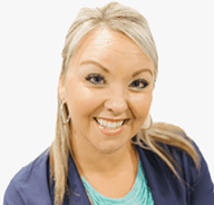 A smiling woman with long blonde hair, large hoop earrings, and wearing a teal top and navy blazer, posed against a plain white background.