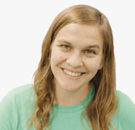 A woman with long, light brown hair and a green shirt smiles at the camera against a plain white background.