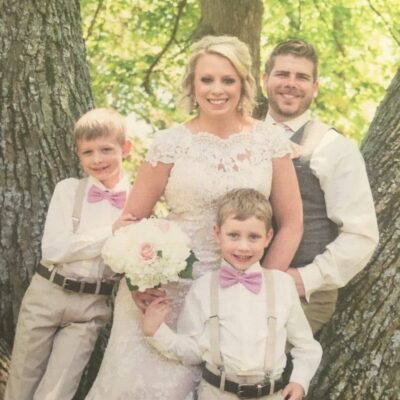 Sarah is pictured outdoors with her family in her wedding gown