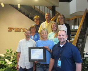 Fey Industries employees hold the plaque honoring the company's Quality Certification Alliance Accreditation