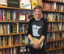 Book shop owner Heather King standing among shelves full of books