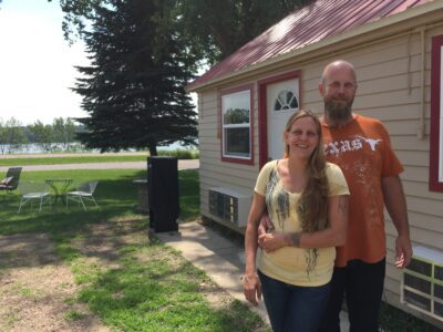 Owners Tami and Chad Benck are pictured outside with one of the lodge's rental units in the background