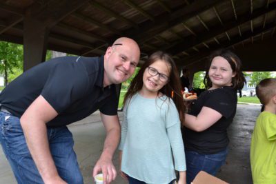 BIO Legacy Board Member Justin Vogt poses with two girls under a picnic shelter