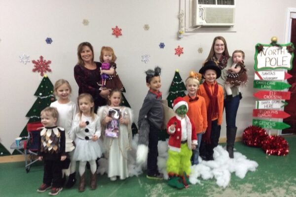 a group of kids and adults standing in a row wearing Christmas costumes