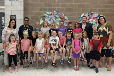 A large group of elementary students gather in rows for a photo with SWIF staff and Emerging Leaders Cabinet members.