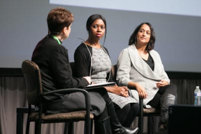 Diana is asking a question of Gigi and Nisha as all three are seated in a slight semicircle on stage.