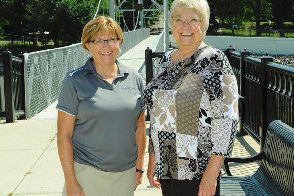 Peg and Avis are pictured standing next to one another in front of Granite Falls' iconic foot bridge.