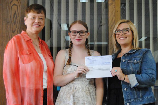 Jessica hands off a grant check to Karen and Ka representing the Diner's Club.