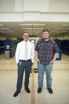 Principal Joyce and Parker stand side-by-side in a school hallway