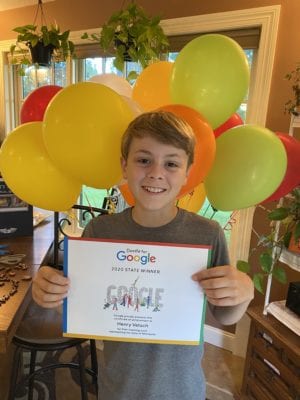 A boy holds a certificate from Google and stands in front of a cloud of balloons.