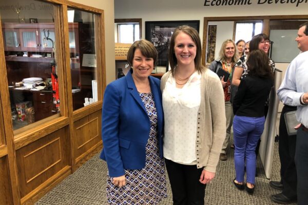 Jodi and Sen. Amy Klobuchar pose together for a photo in a hallway