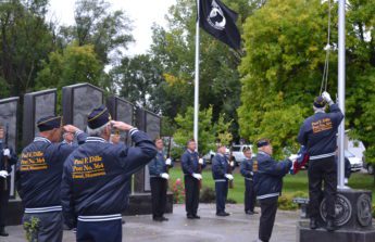 Dassel American Legion Post 364 members raise the American flag