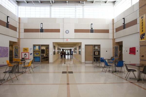 A commons space in Windom Area Schools with students coming down a hallway from a distance