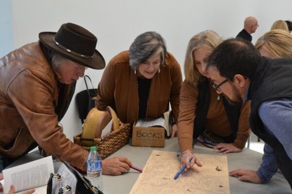 Super and a group of SWIF staff examine a map with Dakota place names