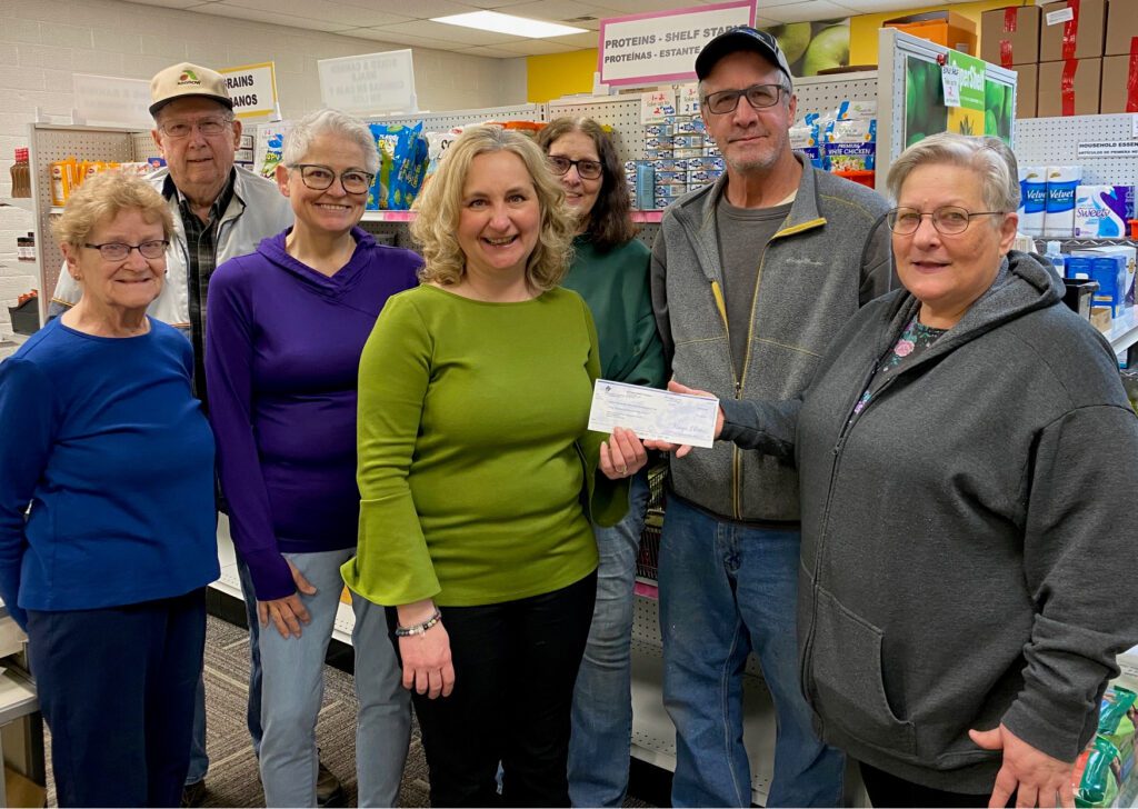 Nancy Fasching, from Southwest Initiative Foundation, presenting a check to a group of people from the Kitchen Table Food Shelf