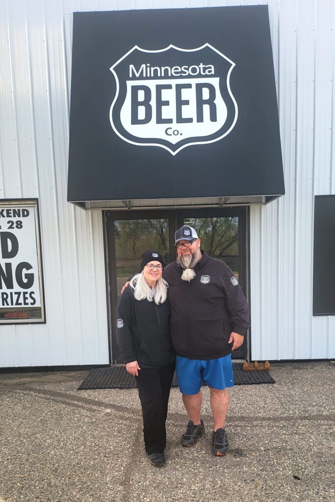 Roxanne and Chris standing in front of their Minnesota Beer Company