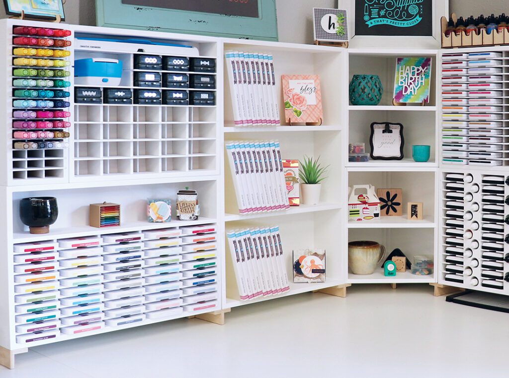 White shelving with colorful papers and craft supplies arranged in a corner.