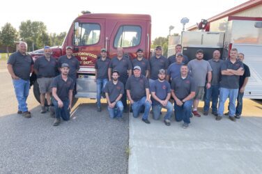 Members of the Cottonwood Fire Department pose for a group photo with a fire truck.