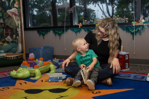 A mother plays with her young child at the library.