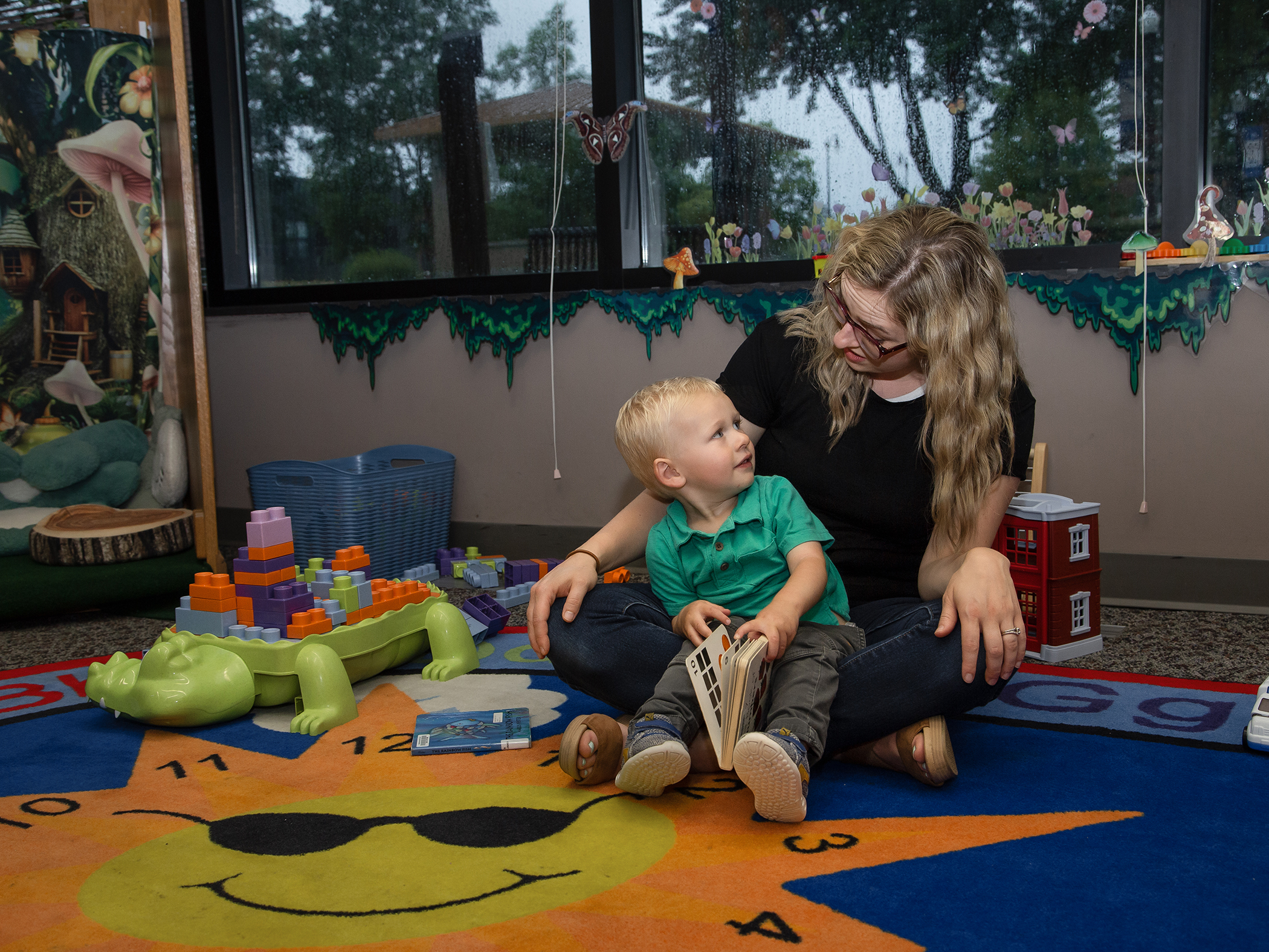 A mother plays with her young child at the library.