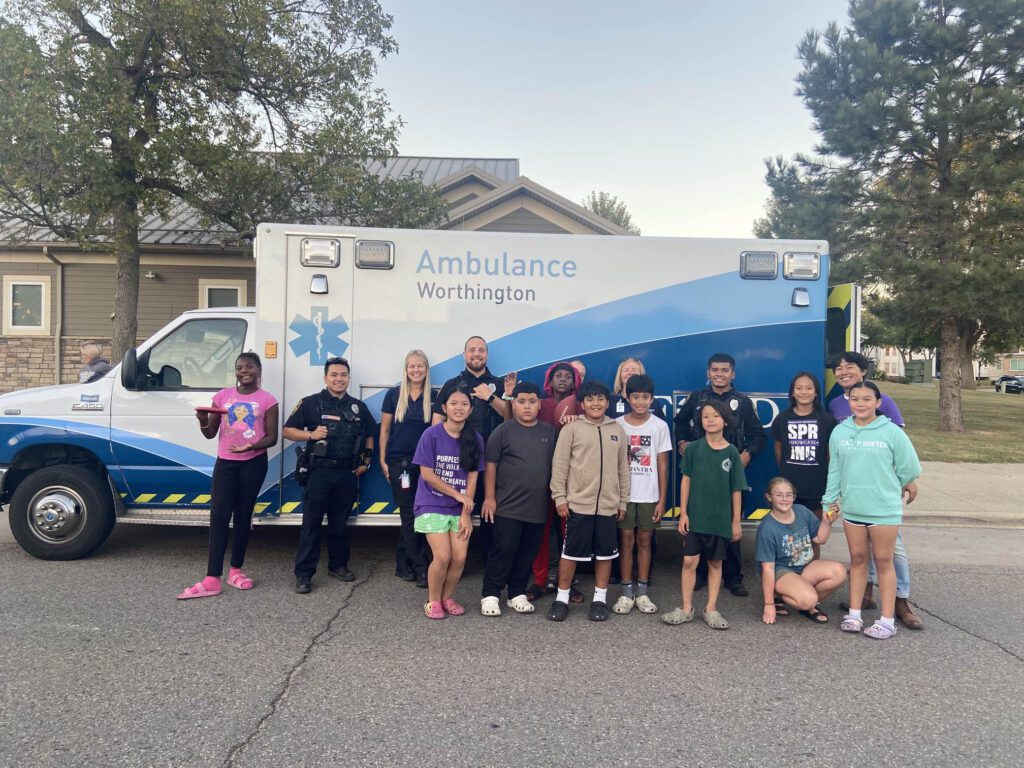 A group of kids and first responders pose for a photo with the ambulance Welcoming Week in Worthington.