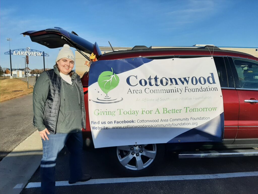 Board member Heather Bitker shows off the Cottonwood Area Community Foundation banner on a minivan for trunk or treat.