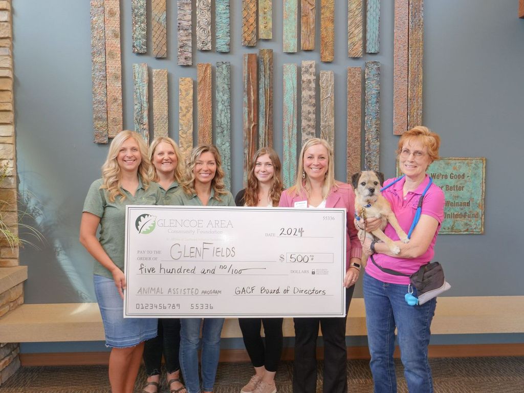 Glencoe Area Community Foundation Board Members present a giant grant check to GlenFields for animal assisted activites.