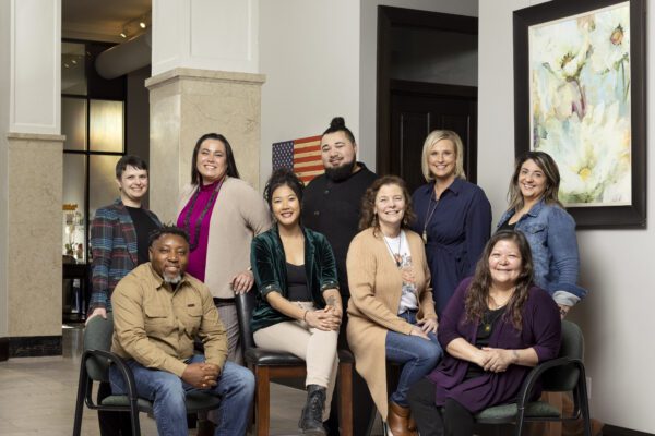 A group of social entrepreneurs pose for a photo, some sitting and some standing.