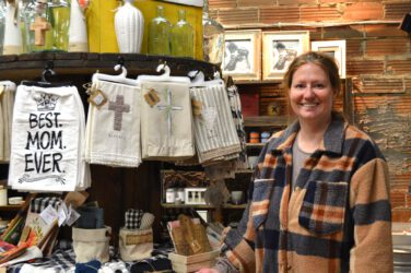 Melissa stands next to a display inside the store featuring hand towels.