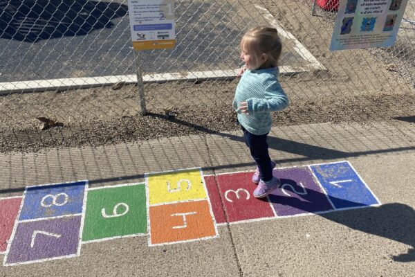 A young child gets ready to jump from one hopscotch square to the next on the Born Learning Trail in Madison.