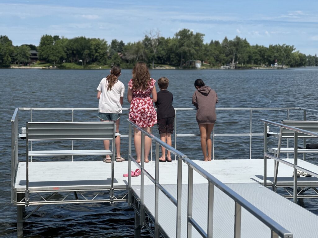A group of children stand on the new metal pier in Balaton looking out at Lake Yankton.