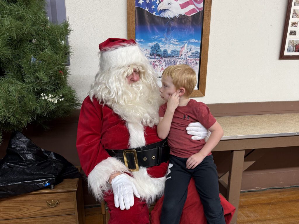 Santa listens to a young child's wish list at Morton Area Community Foundation's Kids Night.