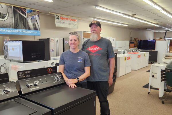 Megan and Brent stand inside their Windom store, surrounded by appliances.