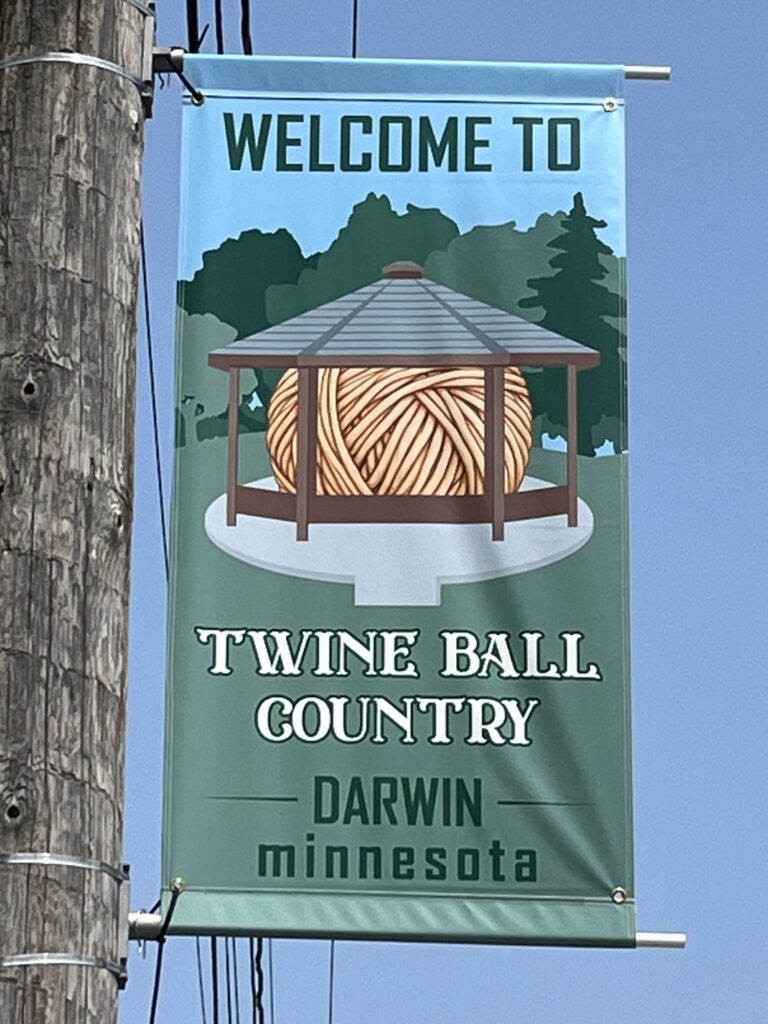 Hanging light pole banner that reads, "Welcome to Twine Ball Country, Darwin Minnesota"