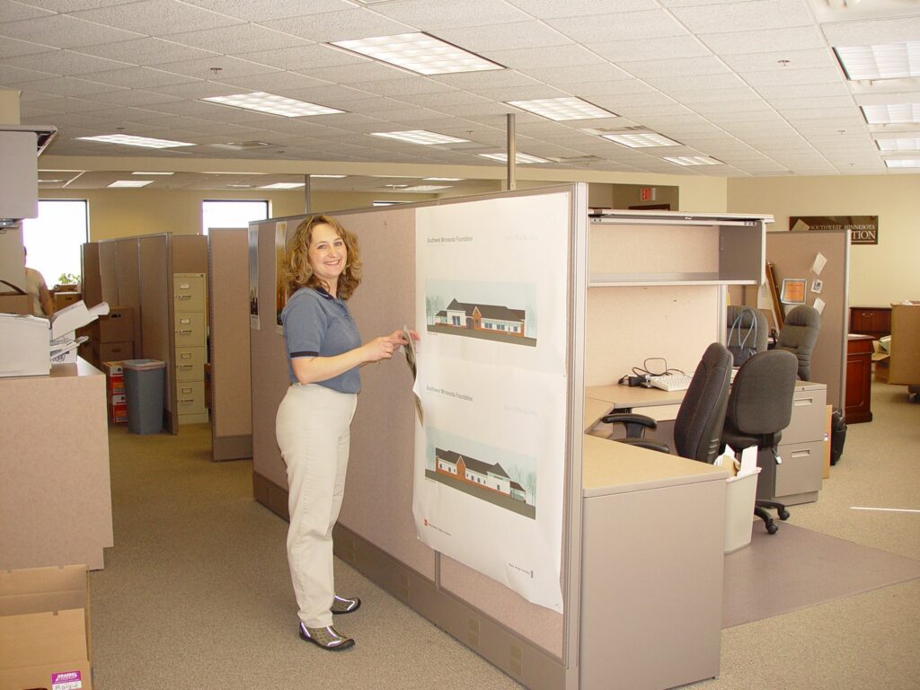 Nancy gets ready to move from SWIF's former office by taking down posters from a cubicle.