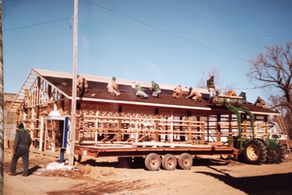 A group of people work on the roof of a framed building that would become the Porter Community Cafe.